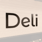 Modern collection's Deli department wayfinding sign that is wall mounted dimensional wood letters with metal laminate faces.