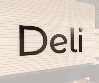 Modern collection's Deli department wayfinding sign that is wall mounted dimensional wood letters with metal laminate faces.