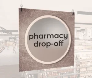 Modern Collection's large department sign with digitally printed text "pharmacy drop-off" centered on a circular overlay.