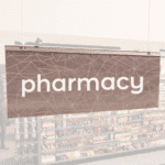 Modern Collection's singled sided small hanging department sign with digitally printed white dimensional text "pharmacy."