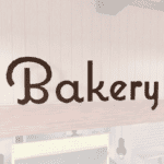 Natural Collection's wayfinding Bakery department sign that is wall mounted with dimensional wood letters and a painted finish