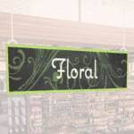 Natural Collection's wayfinding hanging department sign with white text in the center of the signs reads "Floral" on 6 mil PVC