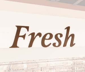 Traditional Collection's wayfinding Produce department sign with the text "Fresh," in dimensional painted wood letters.