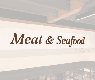 Traditional Collection's wayfinding Meat dept sign with the text "Meat & Seafood," in dimensional painted wood letters.